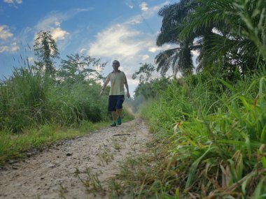 Kırsal yolda tek başına koşan bir adam.