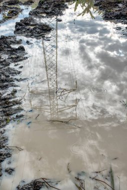 Elektrik iletim kulesinin etrafındaki çamurlu zemin