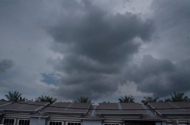 Yerleşim yerlerinin üzerinde karanlık bulutlu gökyüzü