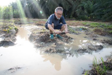 İzole edilmiş çiftlik havuzunda cep telefonuyla fotoğraf çeken bir adam..