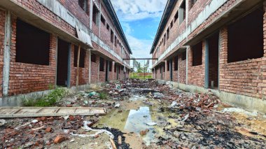 Bitmemiş inşaat binasının etrafında toplanan durgun yağmur suyu havuzu.