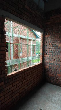 either looking out the window or door frame the outdoor construction site at early dusk or dawn time .