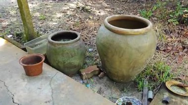 abandoned or thrown away old vintage clay big and small size clay jars at the isolated farm.