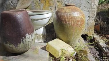 abandoned or thrown away old vintage clay big and small size clay jars at the isolated farm.