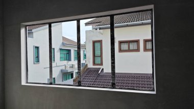 Ya pencereden dışarı bakıyor ya da inşaat sahasının dış çevresini çerçeveliyor..