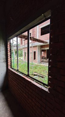 Ya pencereden dışarı bakıyor ya da inşaat sahasının dış çevresini çerçeveliyor..