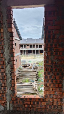 Ya pencereden dışarı bakıyor ya da inşaat sahasının dış çevresini çerçeveliyor..