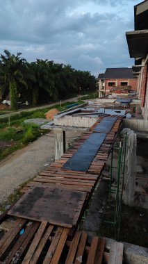 Yarışın etrafındaki olay yeri, balkondan bakan iki katlı bir ev..