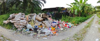 Perak, Malezya. Ekim 27. 2025: KgKoh çiftliğindeki açık alanda yakılacak atık madde yığınlarıyla dolu bir çöp sahasının manzarası.