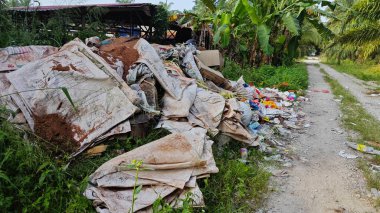 Perak, Malezya. Ekim 27. 2025: KgKoh çiftliğindeki açık alanda yakılacak atık madde yığınlarıyla dolu bir çöp sahasının manzarası.