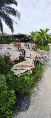 Perak, Malezya. Ekim 27. 2025: KgKoh çiftliğindeki açık alanda yakılacak atık madde yığınlarıyla dolu bir çöp sahasının manzarası.