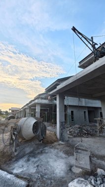 İnşaat alanında çimento kaldırmak için metal kovayla beton karıştırıcı ve ip makarası..