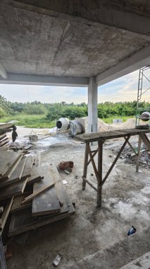 İnşaat alanında çimento kaldırmak için metal kovayla beton karıştırıcı ve ip makarası..