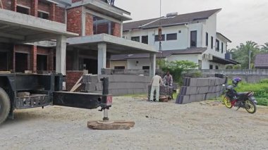 Perak, Malezya. 29 Ekim 2025: Permai inşaat alanındaki yeni binanın çatısındaki işçilere vinç servis kamyonunun çatı bloğunu kaldırması. Kg Koh. 