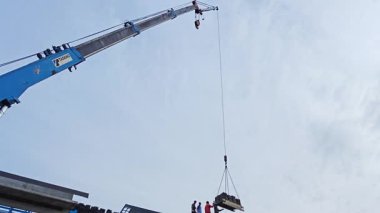 Perak, Malezya. 29 Ekim 2025: Permai inşaat alanındaki yeni binanın çatısındaki işçilere vinç servis kamyonunun çatı bloğunu kaldırması. Kg Koh. 