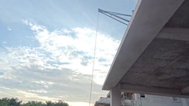 İnşaat alanında çimento kaldırmak için metal kovayla beton karıştırıcı ve ip makarası..