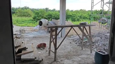 İnşaat alanında çimento kaldırmak için metal kovayla beton karıştırıcı ve ip makarası..