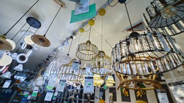 Perak, Malezya. 3 Kasım 2025: Moonlighting Shop, Sitiawan 'da sergilenmek üzere tavana asılmış çok kollu lamba ya da süs eşyası çeşitliliği.