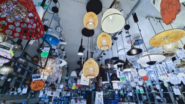 Perak, Malezya. 3 Kasım 2025: Moonlighting Shop, Sitiawan 'da sergilenmek üzere tavana asılmış çok kollu lamba ya da süs eşyası çeşitliliği.