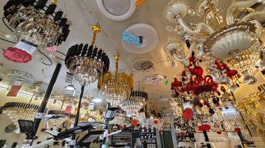 Perak, Malezya. 3 Kasım 2025: Moonlighting Shop, Sitiawan 'da sergilenmek üzere tavana asılmış çok kollu lamba ya da süs eşyası çeşitliliği.