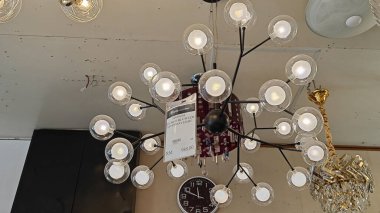 Perak, Malezya. 3 Kasım 2025: Moonlighting Shop, Sitiawan 'da sergilenmek üzere tavana asılmış çok kollu lamba ya da süs eşyası çeşitliliği.