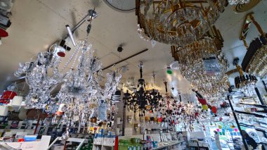 Perak, Malezya. 3 Kasım 2025: Moonlighting Shop, Sitiawan 'da sergilenmek üzere tavana asılmış çok kollu lamba ya da süs eşyası çeşitliliği.