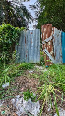 Paslı çinko çatı örtüsü çiftliğe giriş kapısı olarak kullanılıyor..