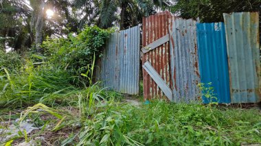 Paslı çinko çatı örtüsü çiftliğe giriş kapısı olarak kullanılıyor..
