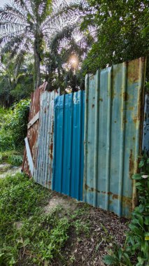 Paslı çinko çatı örtüsü çiftliğe giriş kapısı olarak kullanılıyor..