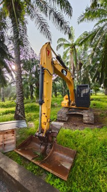 Perak, Malezya. 10 Kasım 2025: Çekiç tarım buldozerli Tırtıl Kazıcısı, izole Palm Petrol Çiftliği 'ne park etmiş pist tipi traktör, Kg Koh.