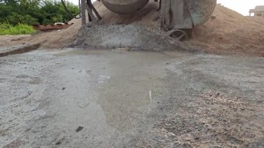 İnşaat alanındaki kum yığınının yanında eski bir çimento karıştırma makinesi..