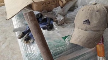 Perak, Malezya. 15 Kasım 2025: Güvenlik botu, lastik ayakkabı, çorap, trolly, kürek ve başlık gibi ekipmanların sahnesi.