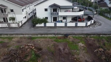 Çiftlik ve banliyö arasındaki kaldırımda insansız hava aracı uçuran bir adamın görüntüsü.. 