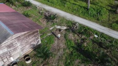 Çiftlikteki terk edilmiş kulübede insansız hava aracı uçuran bir adamın hava görüntüleri..  