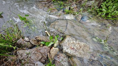 Yağmur suyunun güzel manzarası insan yapımı drenaj siperi boyunca akıyor..