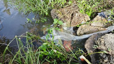 Yağmur suyunun güzel manzarası insan yapımı drenaj siperi boyunca akıyor..