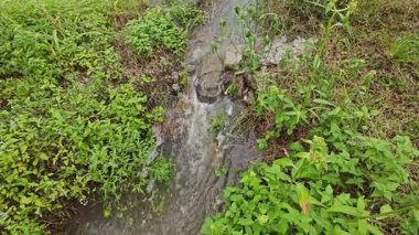 Yağmur suyunun güzel manzarası insan yapımı drenaj siperi boyunca akıyor..