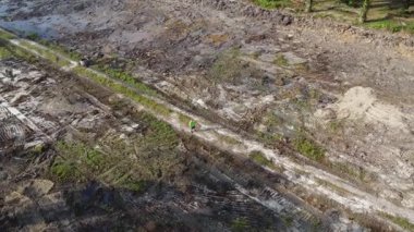 Boş tarım arazisinin temiz ya da düz arazisinde insansız hava aracı uçuran bir adamın çevresel hava görüntüleri..