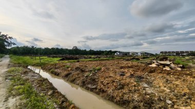 Çiftliğin çevresindeki temiz arazide insan yapımı toprak yol ve drenaj sisteminin manzarası..