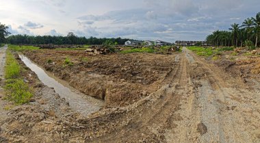 Çiftliğin çevresindeki temiz arazide insan yapımı toprak yol ve drenaj sisteminin manzarası..