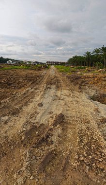 Çiftliğin çevresindeki temiz arazide insan yapımı toprak yol ve drenaj sisteminin manzarası..