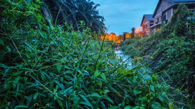 İzole edilmiş toprak yolun gece manzarası. Yakınlardaki sokak lambası alanına doğru gölet çukurları var..