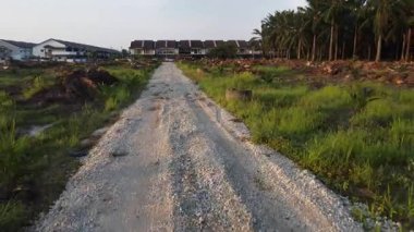 Tarlaya giden izole toprak yolun havadan görüntüsü..