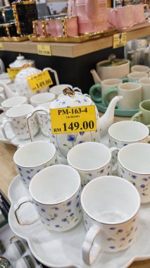 Perak, Malezya. 30 Aralık 2025: SP Duty Free Pangkor Mart 'ta tepsiler gösterilip satılana kadar demlik, tava, çay seti, fincan, tabak, kase, bıçak gibi mutfak aletlerinin çeşitliliği.