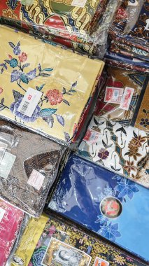 Perak, Malezya. 30 Aralık 2025: SP Duty Free Pangkor Mart 'ta satılmak üzere plastik torbalara doldurulmuş geleneksel çeşitli Batik sarong kumaşı.