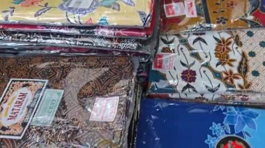 Perak, Malezya. 30 Aralık 2025: SP Duty Free Pangkor Mart 'ta satılmak üzere plastik torbalara doldurulmuş geleneksel çeşitli Batik sarong kumaşı.