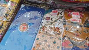 Perak, Malezya. 30 Aralık 2025: SP Duty Free Pangkor Mart 'ta satılmak üzere plastik torbalara doldurulmuş geleneksel çeşitli Batik sarong kumaşı.