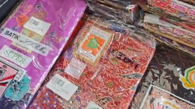 Perak, Malezya. 30 Aralık 2025: SP Duty Free Pangkor Mart 'ta satılmak üzere plastik torbalara doldurulmuş geleneksel çeşitli Batik sarong kumaşı.