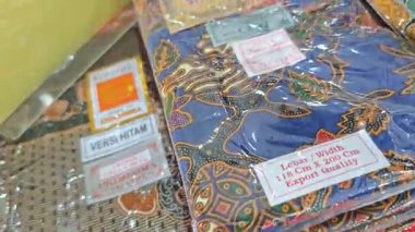Perak, Malezya. 30 Aralık 2025: SP Duty Free Pangkor Mart 'ta satılmak üzere plastik torbalara doldurulmuş geleneksel çeşitli Batik sarong kumaşı.