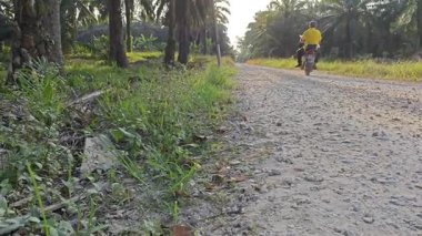 Perak, Malezya. Şubat 02.2026: Kgkoh plantasyonuna giden kırsal izole toprak yolda seyahat eden işçiler için farklı ulaşım araçları sahnesi.